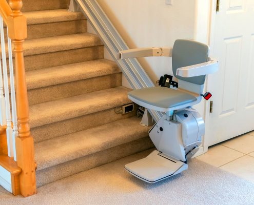 Stairlift chair installed on residential carpeted staircase for home accessibility