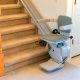 Stairlift chair installed on residential carpeted staircase for home accessibility