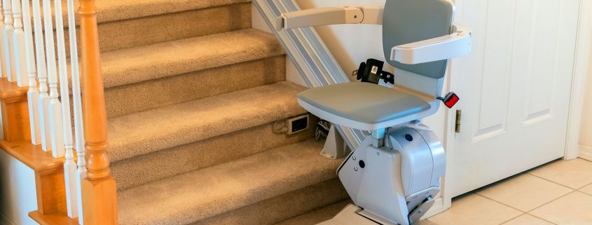 Stairlift chair installed on residential carpeted staircase for home accessibility